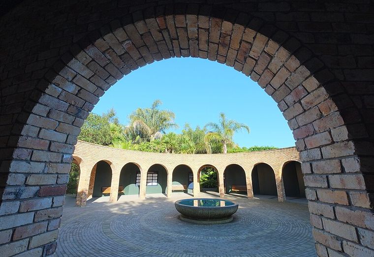 Courtyard and fountain seen through a brick archway