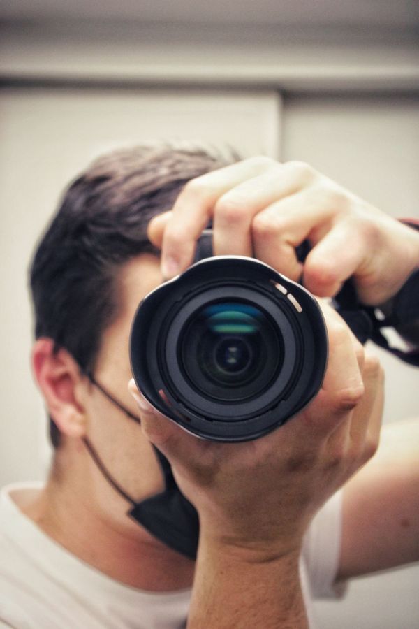 Photographer holding the camera up to the eye with both hands, elbows tucked in